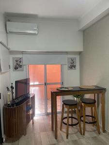 维森特洛佩斯Espectacular Departamento en Vicente Lopez ,Avenida San Martín 2248的厨房配有桌子和2把酒吧凳