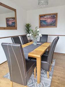 罗瑟勒姆Rowan House Rotherham的一间带木桌和椅子的用餐室