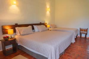 巴里查拉Hotel Hacienda Macedonia的两间位于酒店客房的床,配有两盏灯