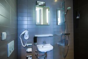 阿姆斯特丹福索冯德尔公园酒店的一间带水槽的浴室和墙上的一部电话
