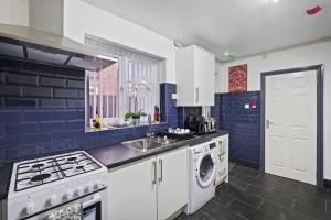 伯明翰Stunning 5 bedroom home families HS2 NEC Airport contactors welcome的蓝色和白色的厨房,配有洗衣机和烘干机