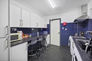 伯明翰Stunning 5 bedroom home families HS2 NEC Airport contactors welcome的厨房配有白色橱柜和蓝色瓷砖