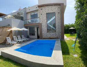 伊察ENCANTADORA Casa de Campo - Ica的别墅前设有游泳池