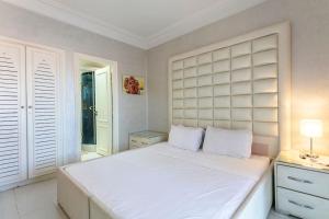 马拉喀什Palm Splendor - Marrakech的卧室配有一张白色大床和床头板