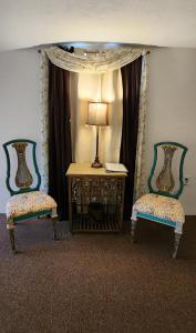 达洛尼加Lily Creek Lodge的两把椅子和一张桌子,在房间里放着一盏灯
