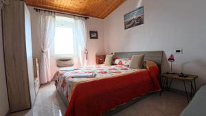 San BernardinoAppartamento Luca e Giulia的一间卧室配有一张带红色毯子的床和窗户。