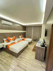亚喀巴Sky Hotel的酒店客房设有两张床和电视。