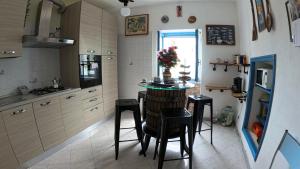 San BernardinoAppartamento Luca e Giulia的厨房配有小桌子和凳子