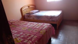 萨利纳斯Puerto Lucía - Salinas Beach的小房间设有两张床和床罩