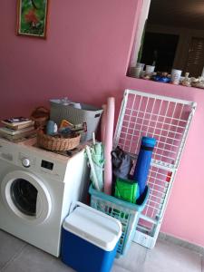圣安娜Sous le manguier的洗衣房配有洗衣机和粉红色的墙壁