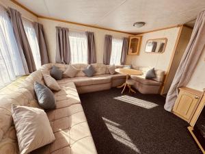 英戈尔德梅尔斯Golden Sands Caravan Hire Ingoldmells- FREE in caravan wifi- Access included to the on site club house, sports bar, arcade, coffee shop We have beach access, a fishing lake and a laundrette的客厅配有沙发和桌子