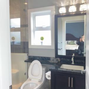 伯纳比Comfortable suite for guests to use independently的一间带卫生间、水槽和镜子的浴室
