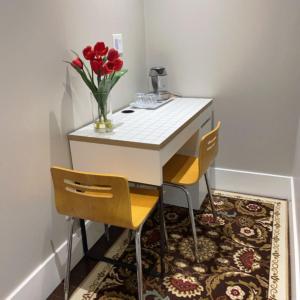 伯纳比Comfortable suite for guests to use independently的小桌子,两把椅子和花瓶