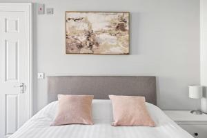 普里茅斯Brand New 5 Bedroom House的白色卧室配有带2个粉红色枕头的床