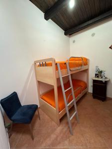 帕尔蒂尼科Orange House的带两张双层床和蓝色椅子的房间