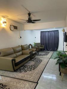 加央#KangaQHomestay99的带沙发和吊扇的客厅