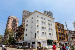 孟买Hotel New Imperial的城市街道上的白色建筑,有建筑
