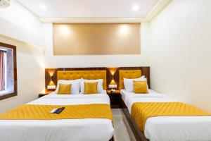 孟买Hotel New Imperial的酒店客房带两张带黄床单的床
