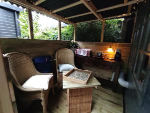 皮滕"Tempat Senang" chalet on the beautiful Veluwe with airco sauna bbq jacuzzi beamer and dog的门廊配有桌椅和书桌