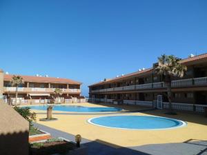 波里斯-德阿沃纳Apartamento Dulce Vista的度假村设有两个游泳池和棕榈树