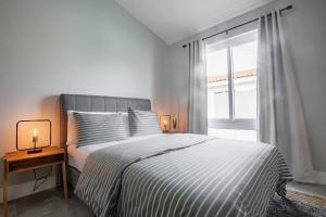 普拉纳维瑙Nearly Oceanfront Blue 3 Bedroom Spacious Villa的白色的卧室设有床和窗户