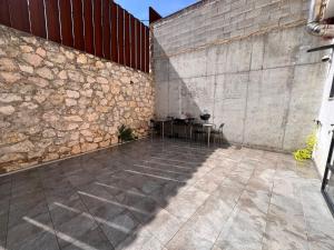 MontichelvoCasa del Pueblo的石头墙边的庭院配有桌子