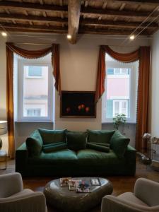 罗马Fontana di Trevi Roma Luxury Suite的客厅设有绿色沙发和2扇窗户。
