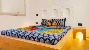 瓦塔穆Casa Maridadi的一间卧室配有一张色彩缤纷的大床