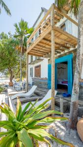 Tintipan IslandCasa Tinti Hotel Boutique的海滩上带木制凉棚的房子