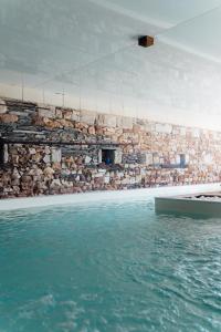 Saint-MathurinCasa Mila & SPA- Chambres d'Hôtes raffinées vue Loire et piscine的一座带石墙和水的游泳池