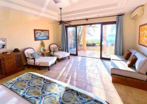 瓜纳卡斯特Villa Durazno的带沙发和椅子的客厅以及大窗户。