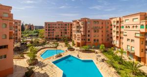 马拉喀什Charming 2-Bed Oasis Pool View的公寓大楼的空中景致,设有2个游泳池