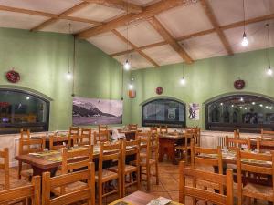 圣马西莫罗西亚特罗酒店的餐厅设有木桌和椅子,拥有绿色的墙壁