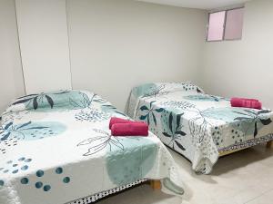 马萨特兰Posada Vacacional Brisas del Mar的两张睡床彼此相邻,位于一个房间里