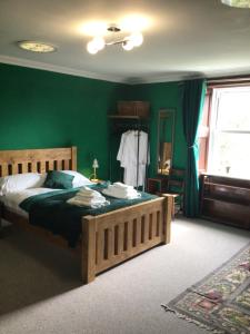 洛克比Mansefield Rooms的一间卧室设有一张带绿色墙壁的大床