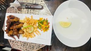 龙杜Shafas Guest House的桌上一盘带鸡肉和薯条的食物