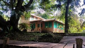 SiquirresESMERALDA LODGE的木质房屋,设有木甲板