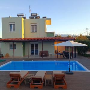 克拉法吉亚Drosoula Villa 3bdr private swimming pool的房屋旁的游泳池配有椅子和遮阳伞