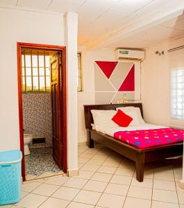 雅温得Appartement chic et spacieux près centre Yaoundé的一间卧室配有一张带红色枕头的床