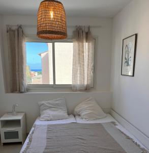 圣艾格夫Saint Aygulf - a 250m de la mer- 3 pieces 45m2的卧室内的一张床位,配有窗户和灯