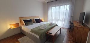 阿祖拉拉Azurara Guesthouse的一间卧室设有一张大床和一个窗户。