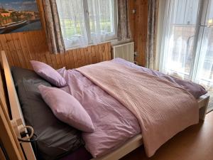 AugioCasa Cascatella的卧室内的一张带粉色毯子和枕头的床