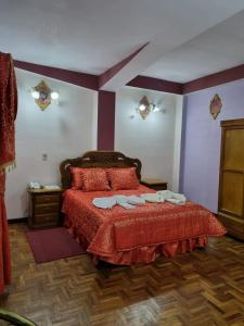 波托西HOTEL SAMARICUSUN的一间卧室配有红色的床和2条毛巾