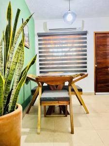 伊斯塔帕Sweet home Ixtapa comfort的木桌和椅子,放在植物间