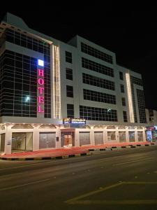 Al Fayşalīyahفندق روزميلون的一座大建筑,上面有 ⁇ 虹灯标志