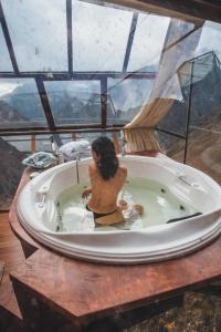奥兰太坦波Vertical Sky Luxury Suites的坐在浴缸中的女性,享有美景
