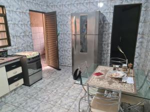 里贝朗普雷托Casa para Temporada Agrishow 2024的厨房配有不锈钢冰箱和桌子
