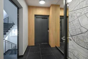 华沙L7 Warsaw Apartments Sauna&Gym的走廊上设有黑色的门,墙上有地图