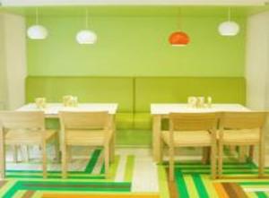 新德里Hotel AMADA Infinity Near Delhi Airport By LA CASA的用餐室设有桌椅和绿色的墙壁