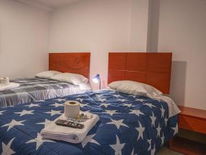 瓦努科YURAQ WASI Hotel/Restobar的一间卧室配有两张带蓝白色棉被的床